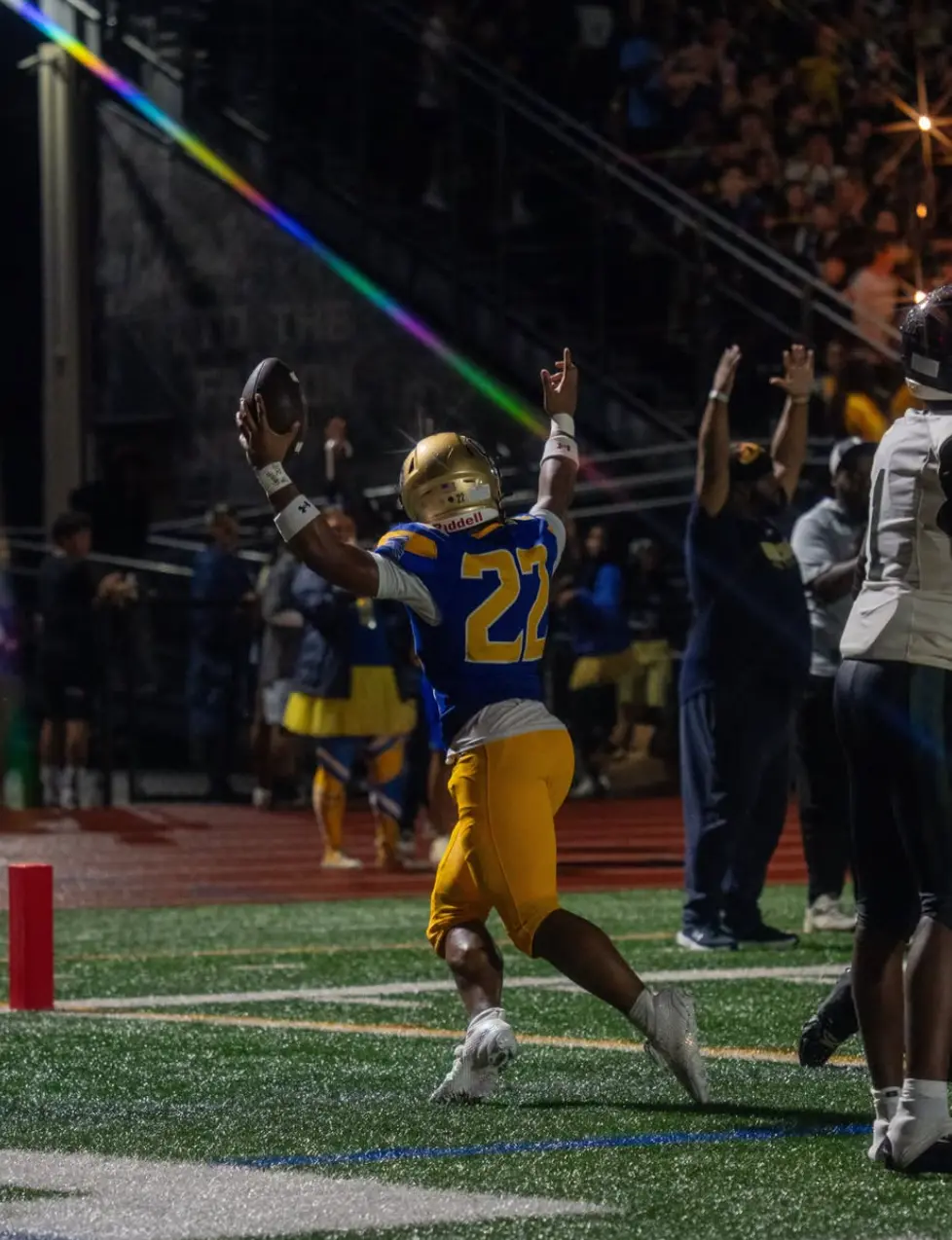Player number 22 celebrating a touchdown with arms raised, ball in hand