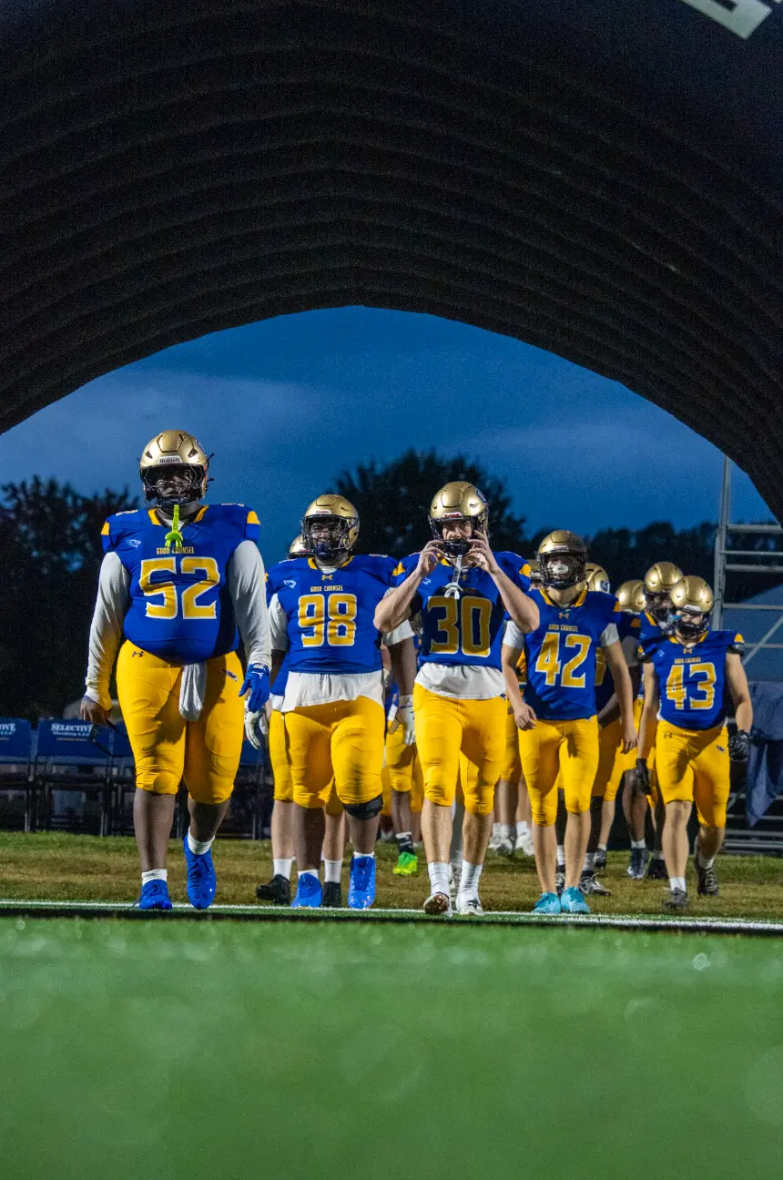 Good Counsel football team walking out of the tunnel under the stadium lights