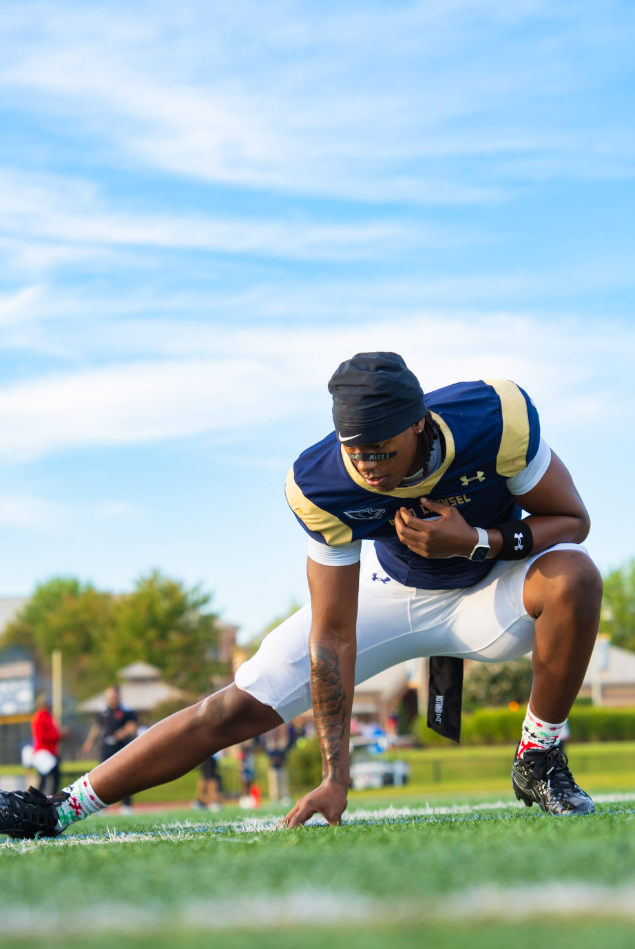 Player stretching during pregame warm-ups under a blue sky