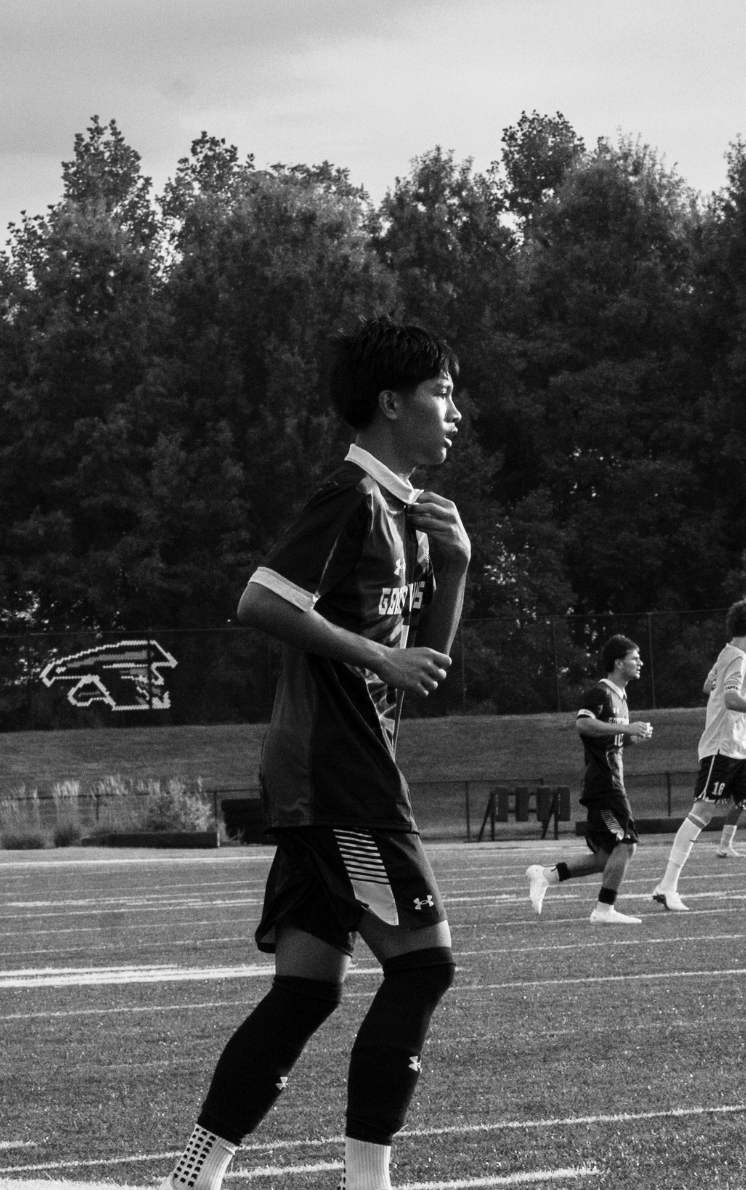 Black-and-white photo of a soccer player adjusting his jersey