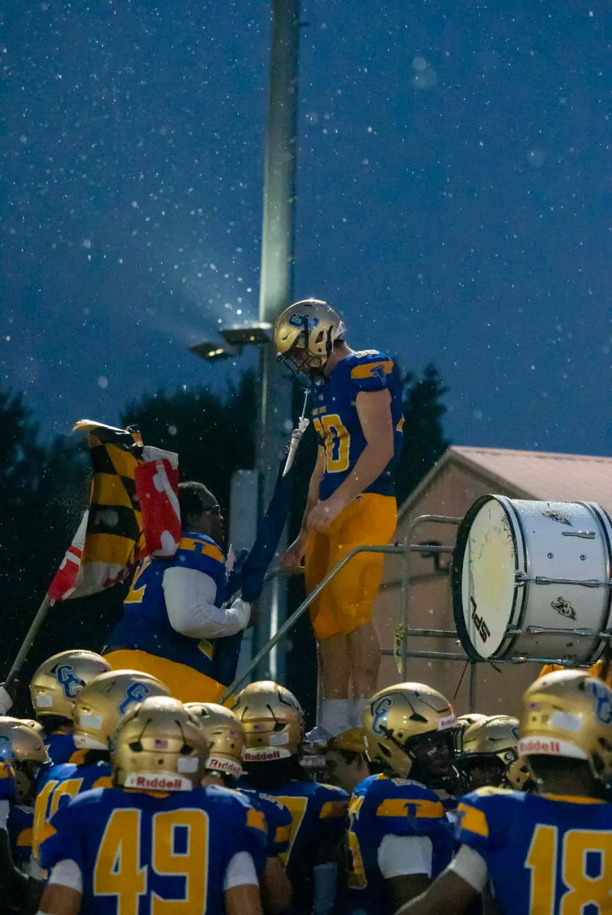 Player on the band ladder saluting the crowd in the rain