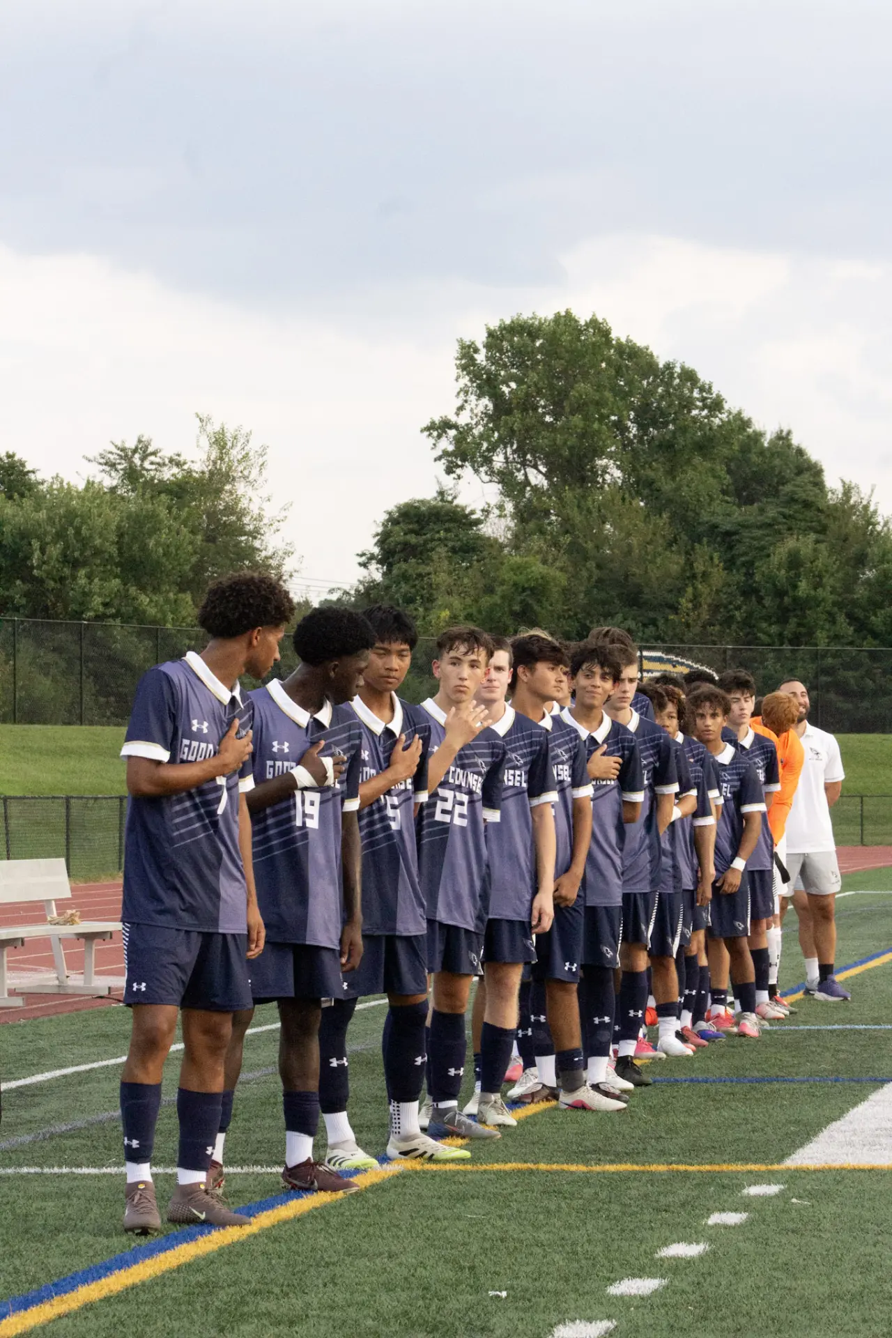 Good Counsel soccer team lined up with hands over hearts before kickoff